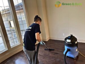 A man cleaning a carpet or floor using a vacuum