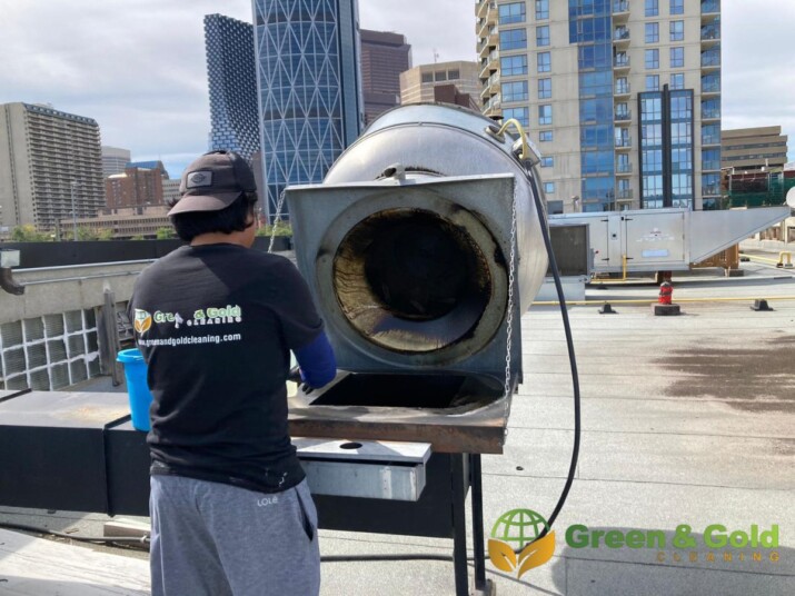 A man cleaning a kitchen hood